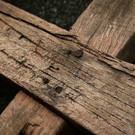 Zwei grobe Holzlatten, zu einem Kreuz zusammengenagelt